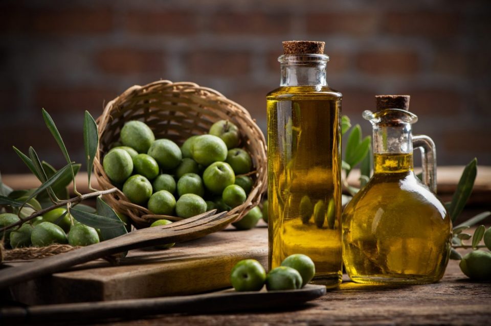 Olives et huile d'olive dans des bouteilles en gros plan